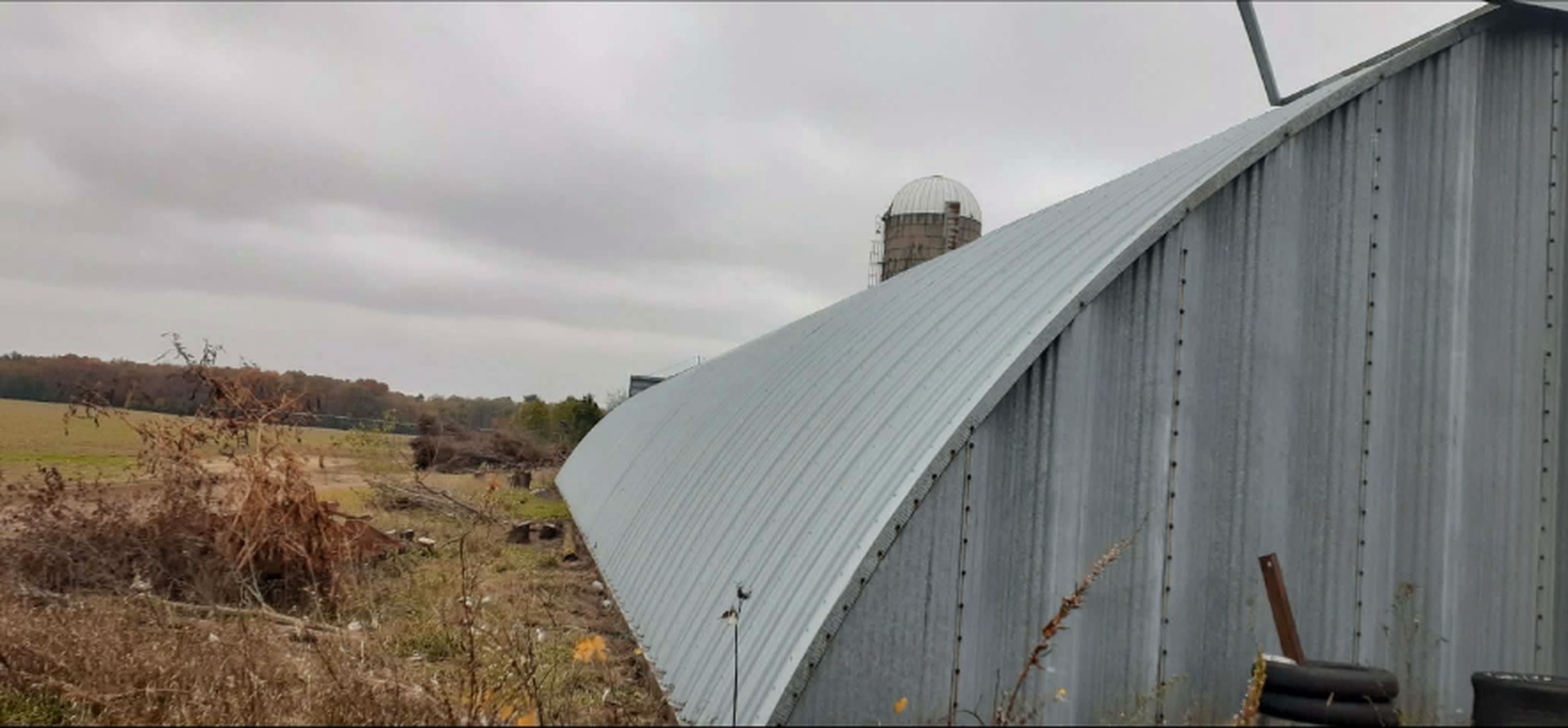 Quonset barn roof coated in a clean even silver-gray finish