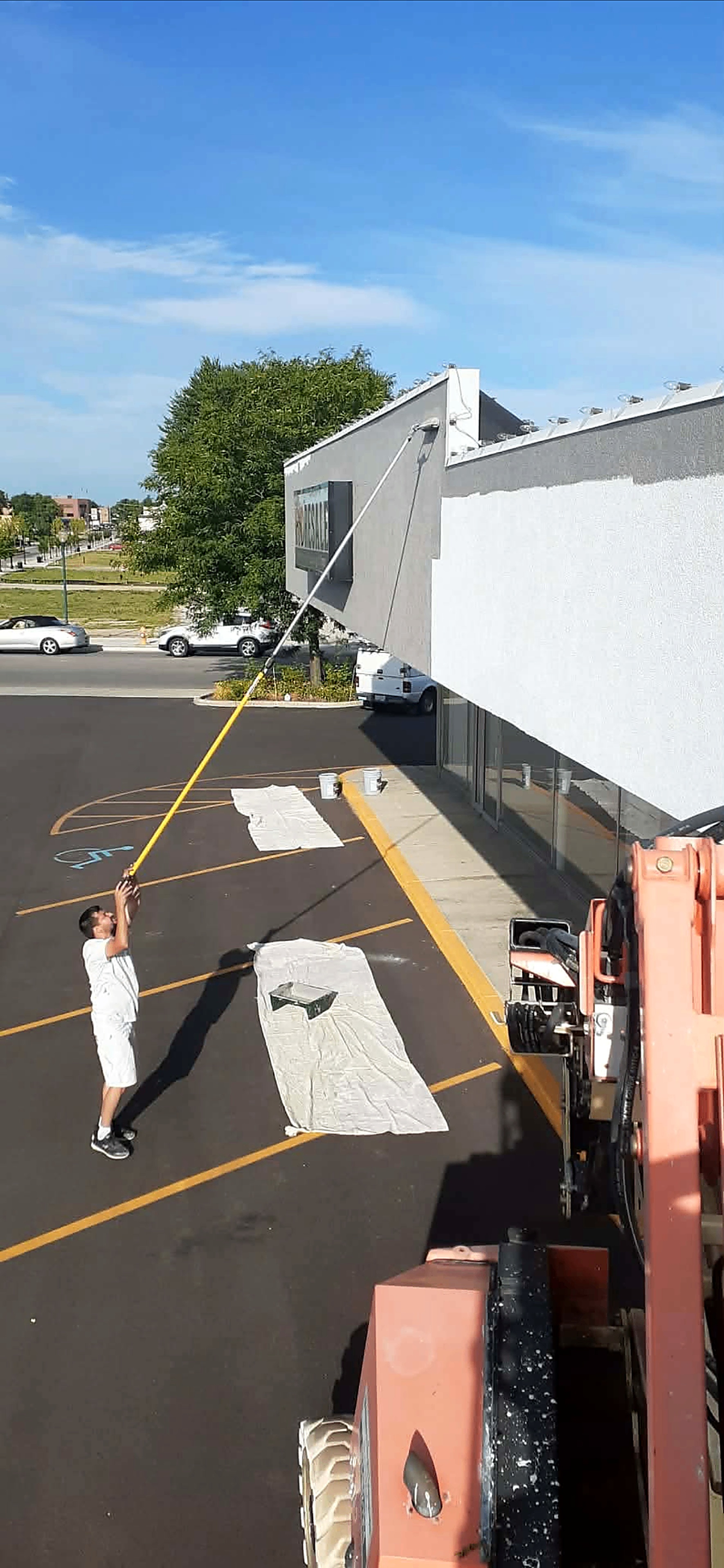 Easy Shopping Place exterior being painted bright white