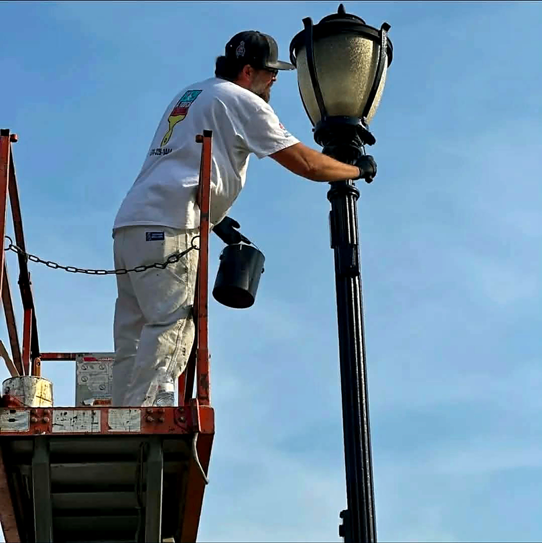 Phil Hillman on a lift painting a light pole on the Cassopolis Street toll road bridge in Elkhart